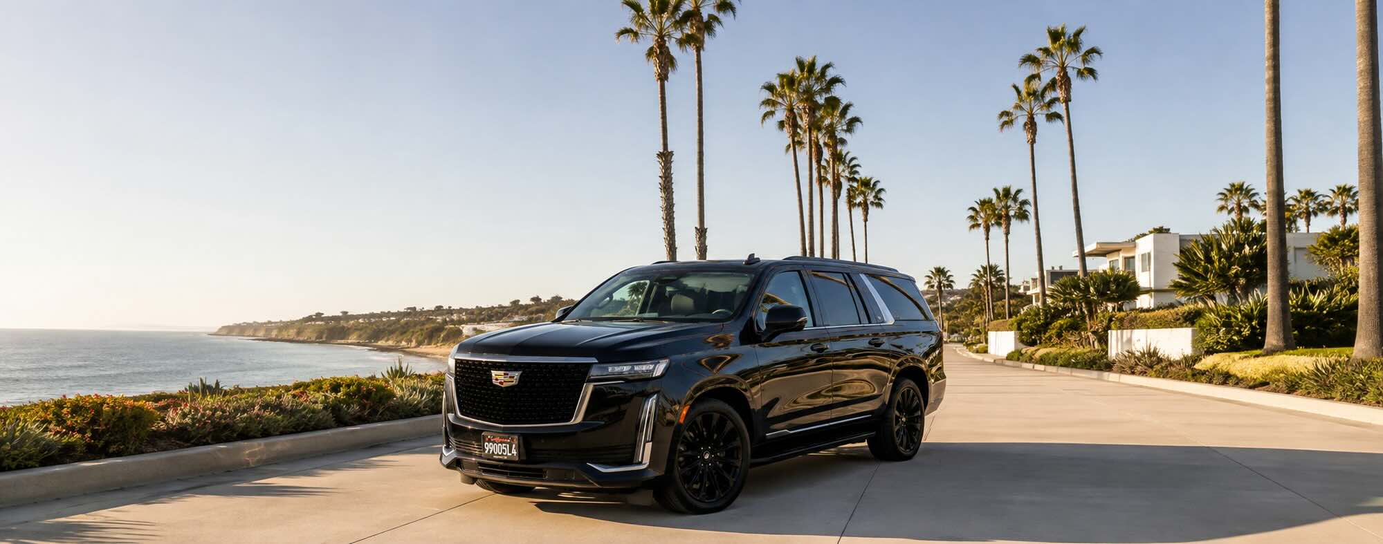Black Cadillac XT6 waiting at the entrance of a coastal Orange County hotel